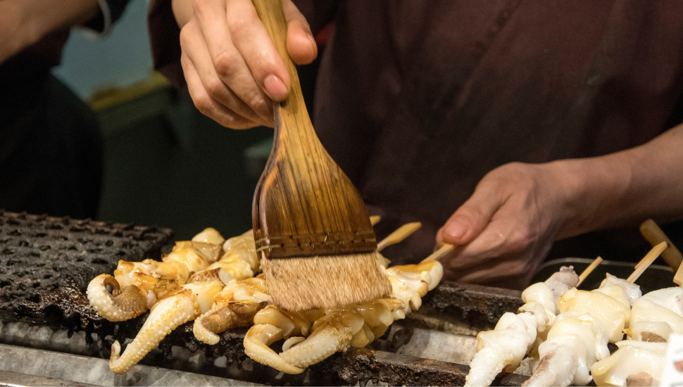 Vendor preparing food at Nishiki market, Kyoto, Japan