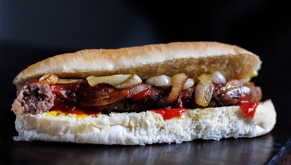 close up of boerewors roll with onions and tomato sauce