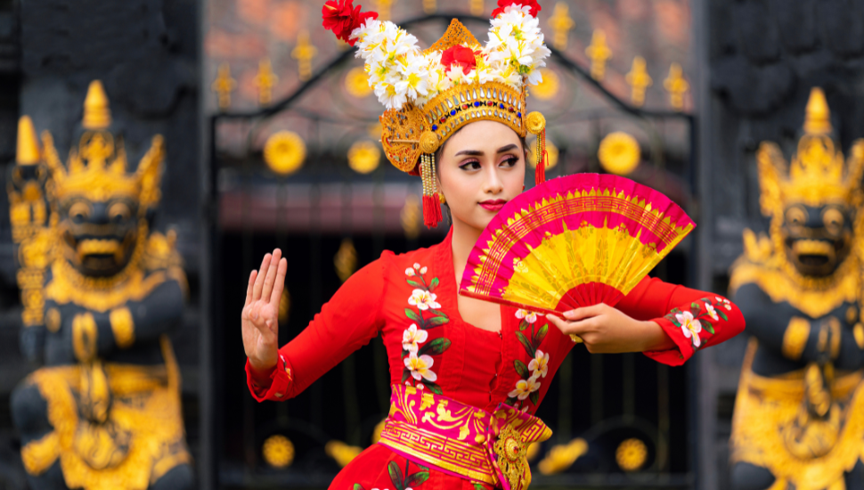 Indonesian girl in traditional dress, dancing at temple in Bali