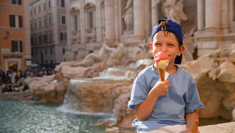Young boy eating ice cream (gelato) near the Trevi Fountain in Rome, Italy