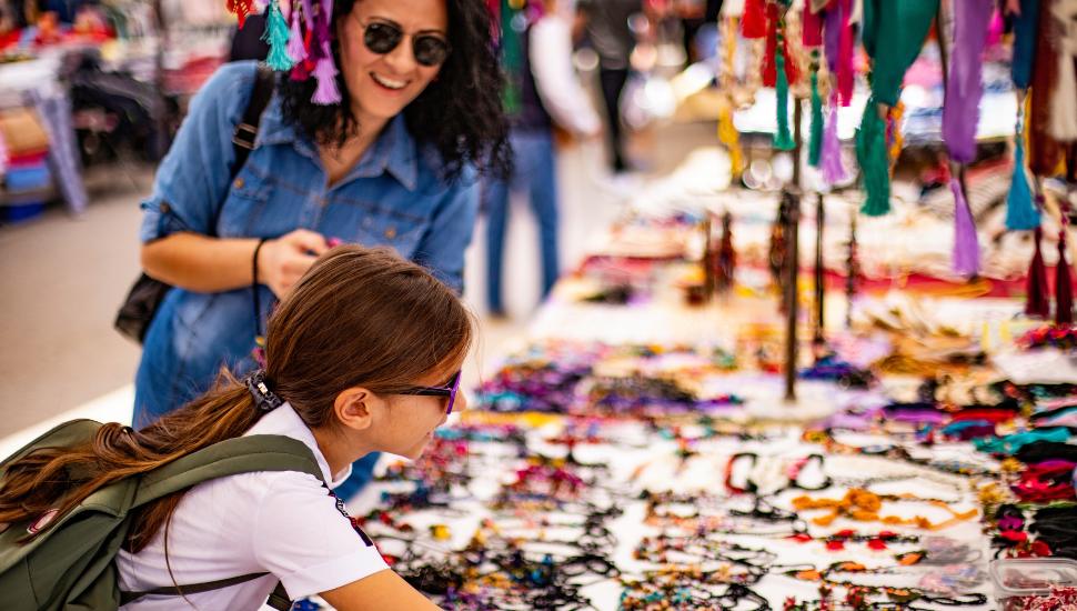 Mother and daughter shopping for souvenirs on holiday