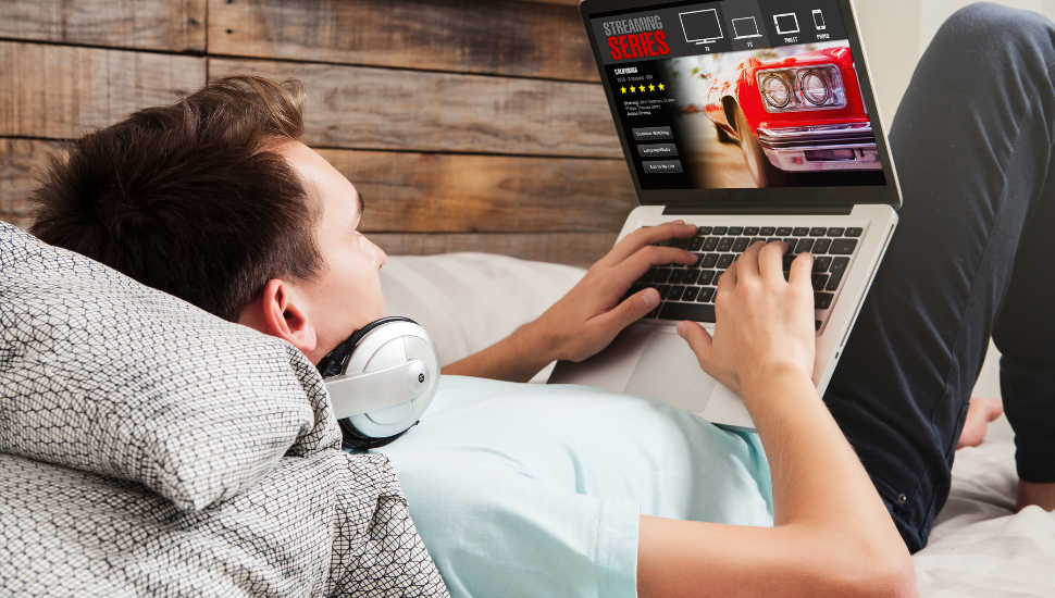 Male backpacker streaming film on laptop