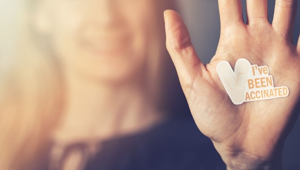 Woman with 'I've been vaccinated' sticker on her hand