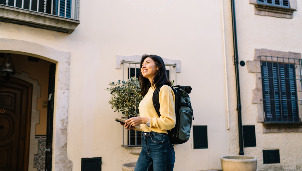 Young female backpacker with map, looking for hostel