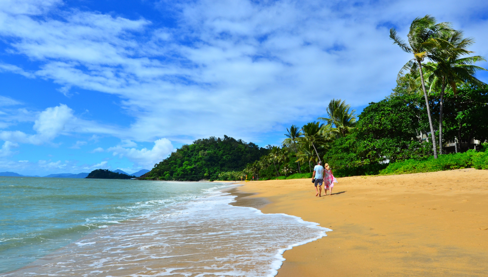 Couple walking on Trinity Beach, Australia