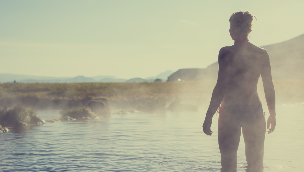 Young woman relaxing in a hot spring in Iceland Landmannalaugar