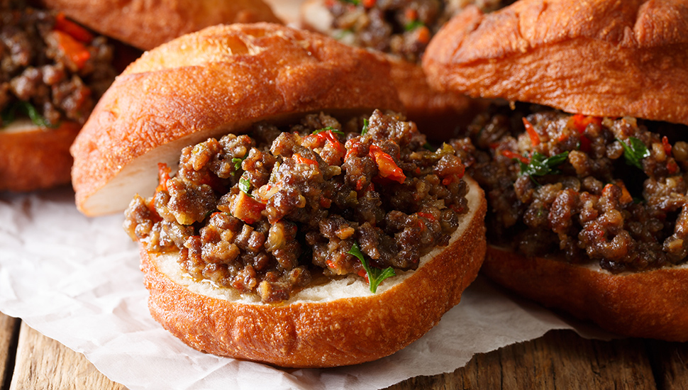 South African food: deep-fried vetkoek sandwich with meat curry close-up. horizontal