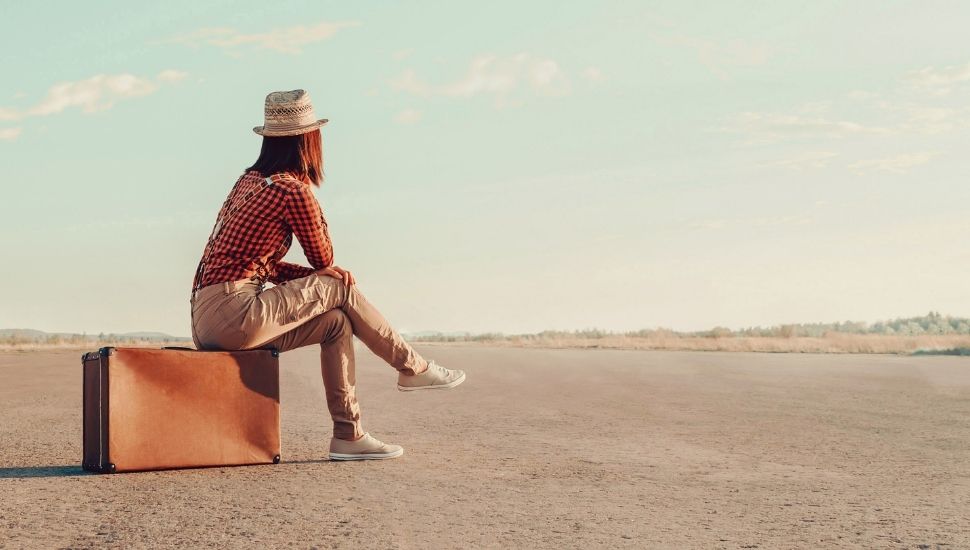 Young girl sitting on a suitcase