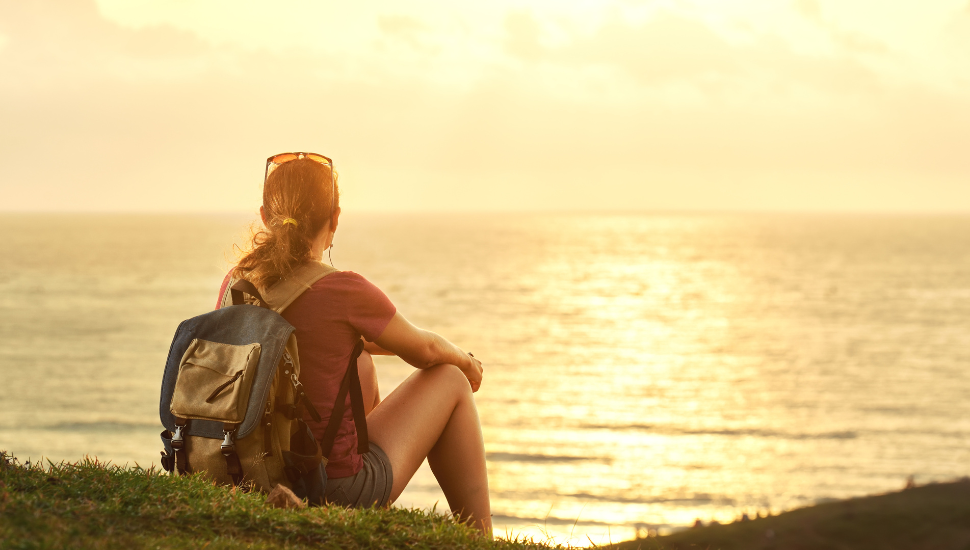 Solo backpacker taking in scenery at coast