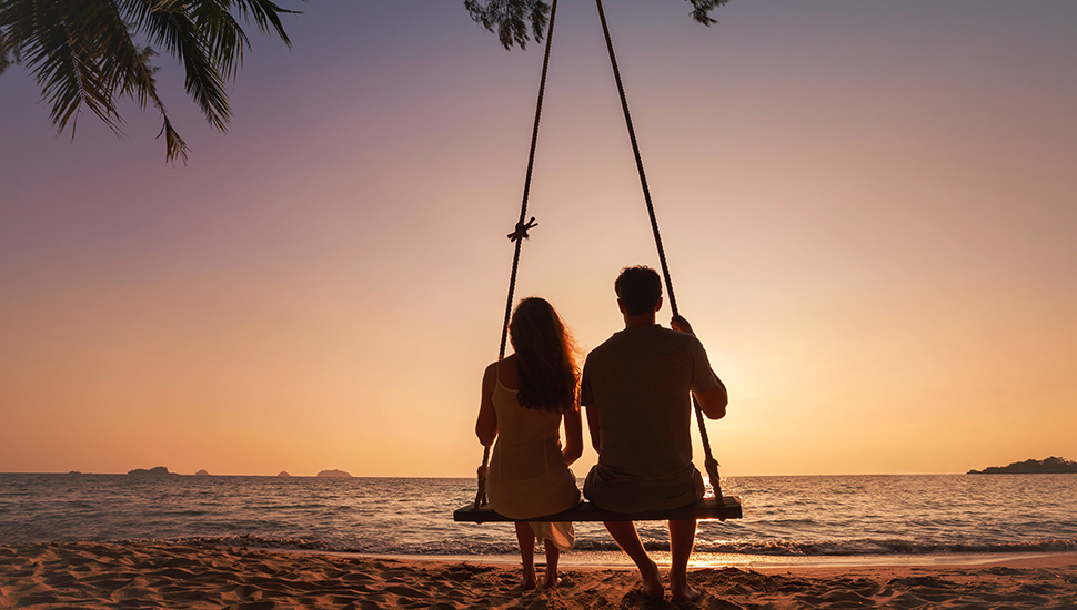 Couple on swing on the beach